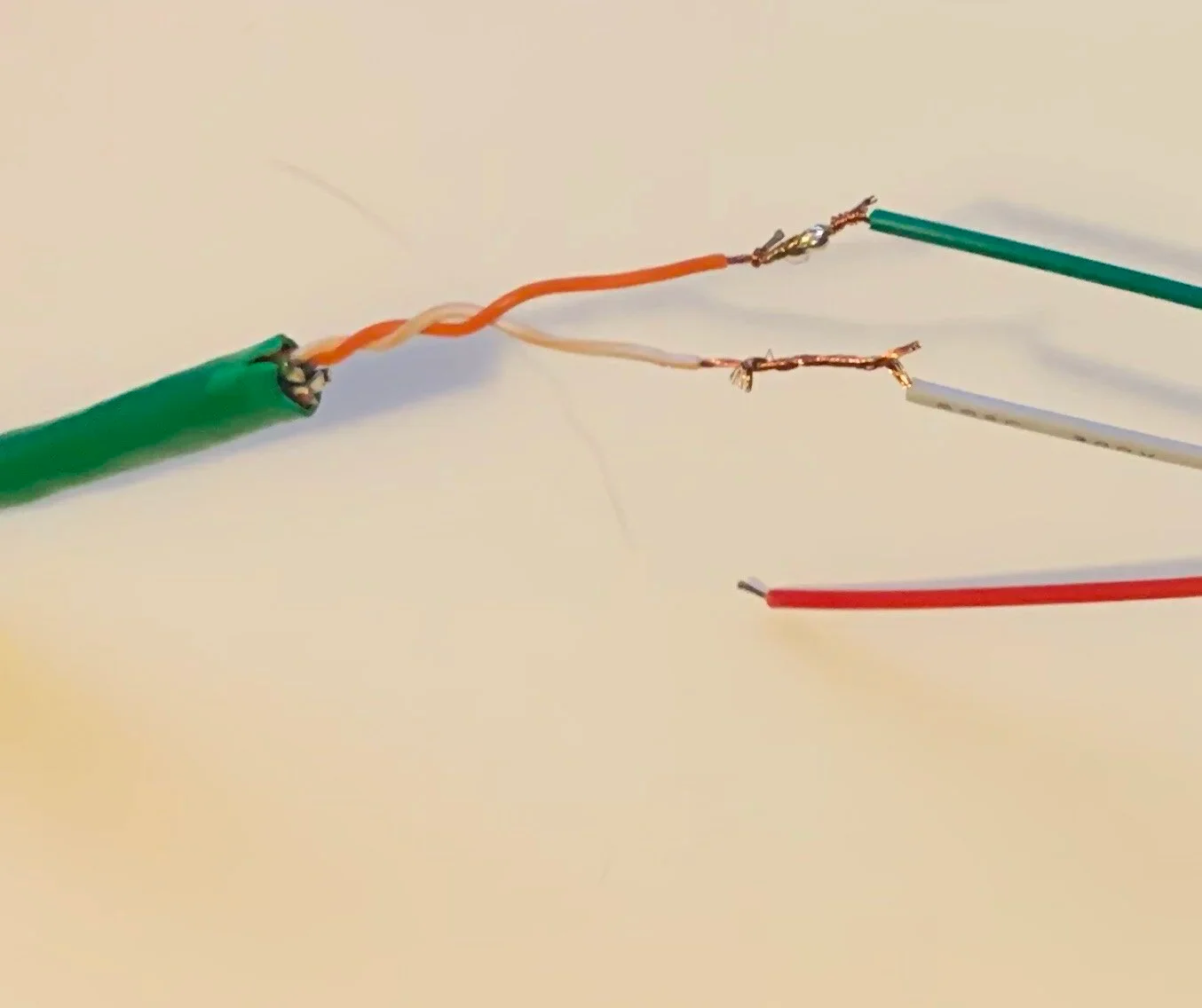 Cut ethernet in half down middle, remove outer sheath with scissors and fingers, cut off all the wires but for the orange and corresponding white, strip the tips of those wires, wrap around ends of JST connector (other end will be connected to LEDs …